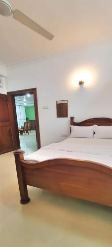 ein Schlafzimmer mit einem großen Holzbett in einem Zimmer in der Unterkunft Beach Road holiday home in Karagampitiya