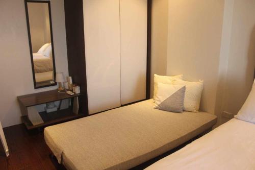 a small bedroom with a bed and a mirror at Tambuli maribago residence condominium in Maribago