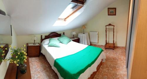 a bedroom with a bed with green and white sheets at Apartamento abuhardillado en pueblo asturiano in Santianes
