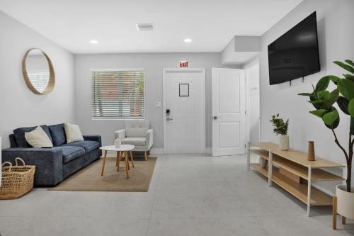 a living room with a blue couch and a tv at Sistrunk Shades Villas #1 - Brand New Townhomes Downtown Fort Lauderdale in Fort Lauderdale