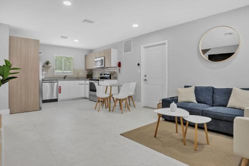 a living room with a blue couch and a table at Sistrunk Shades Villas #1 - Brand New Townhomes Downtown Fort Lauderdale in Fort Lauderdale