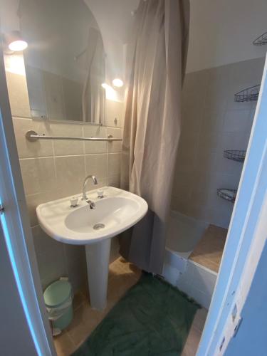 ein Badezimmer mit einem weißen Waschbecken und einer Dusche in der Unterkunft Charmant T3 50m2 plein centre corte 13 cours paoli wifi écran plat lave linge 6 couchages in Corte