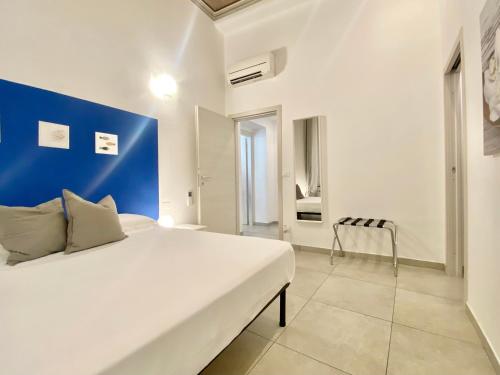 a bedroom with a large bed with a blue wall at Alla Casa Rosa al Mare, Central Seafront Stay, Air Conditioning, Wi-Fi, the Ideal Choice for a Relaxing and Exciting Coastal Escape, with available on request at 20,00 euro per night Private Garage, Welcome kit Priority, Prosecco and Canestrelli in Rapallo