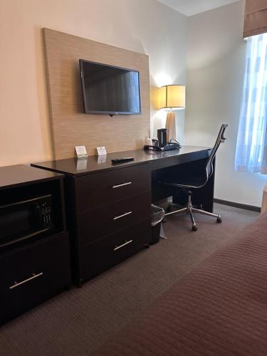 a hotel room with a desk with a television at Sleep Inn & Suites Gulfport in Gulfport