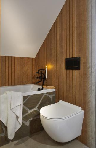 a bathroom with a white toilet and a bath tub at Sielanka Pienińska in Krościenko