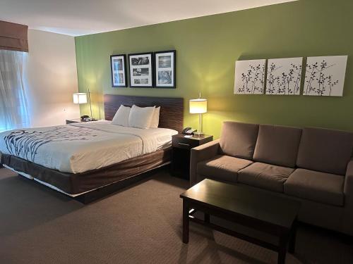 a hotel room with a bed and a couch at Sleep Inn & Suites Gulfport in Gulfport