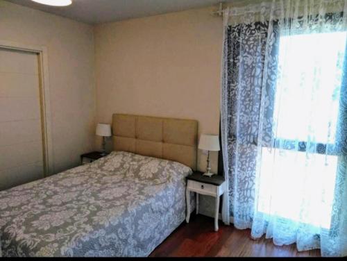 1 dormitorio con 1 cama y una ventana con cortinas en Pirineo Aragonés, en Latas