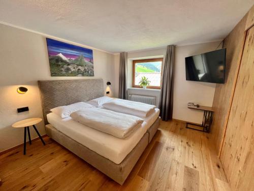 a bedroom with a bed and a flat screen tv at Haus Schrofenstein in Lech am Arlberg