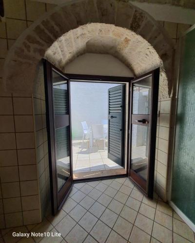 a room with a large window with a view of a patio at La casetta di zia Giuseppina in Alberobello