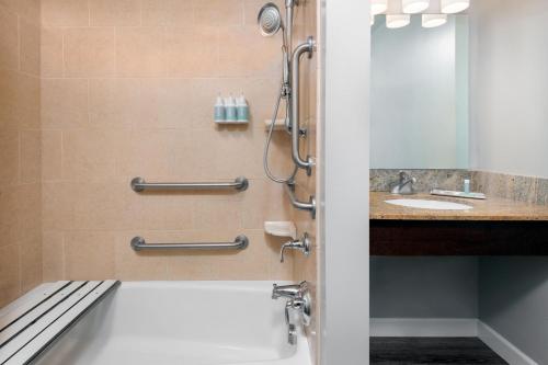 W łazience znajduje się prysznic i umywalka. w obiekcie TownePlace Suites Buffalo Airport w mieście Cheektowaga