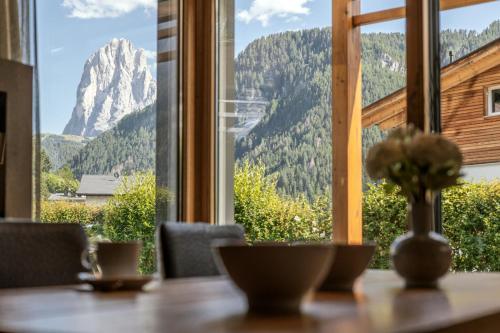 a table with a view of a mountain through a window at Apartments Chalet Anna in Ortisei