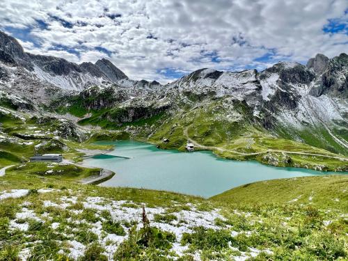 a mountain lake in the middle of a mountain range at Haus Schrofenstein in Lech am Arlberg