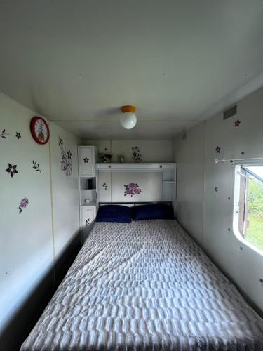 1 dormitorio con 1 cama en una habitación pequeña en Domek holenderski, en Wiele