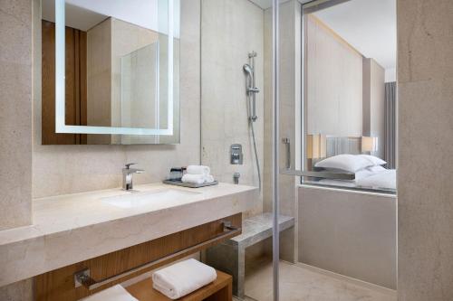 uma casa de banho com um lavatório e um espelho em Four Points by Sheraton Shanghai, Kangqiao em Xangai