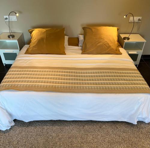 un grand lit dans une chambre avec deux lampes dans l'établissement La Merle, à Veyrier-du-Lac