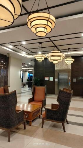 eine Lobby mit Stühlen, einem Tisch und Kronleuchtern in der Unterkunft ALEA RESIDENCES Condo near Airport and MOA! Cozy Place with Main street and Manila Bay view in Manila