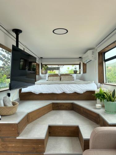 a bedroom in a van with a bed and a couch at Leobus-לאו באס in Menaẖemya