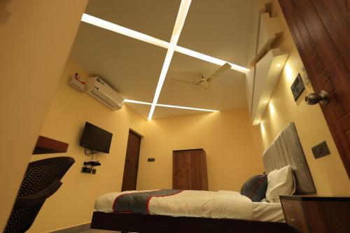 a hotel room with a bed and a ceiling with lights at AMR Inn in Pondicherry
