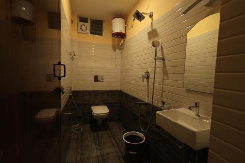 a bathroom with a sink and a toilet at AMR Inn in Pondicherry