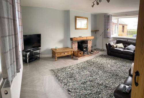 a living room with a couch and a fireplace at Newton Hall farm cottage with amazing views & hot tub in Preston