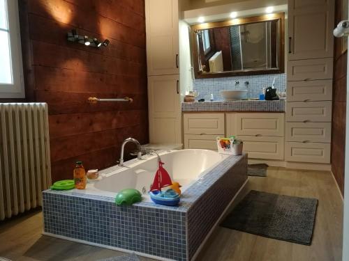 y baño con bañera con lavabo y espejo. en villa Divatte de la Loire en Divatte sur Loire