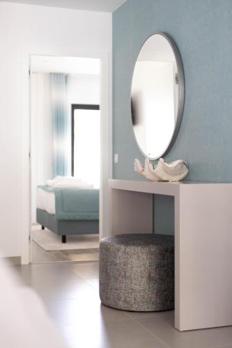 a room with a mirror and a ottoman and a bed at Orange Boutique Residence - Casa Luis Camões in Quarteira