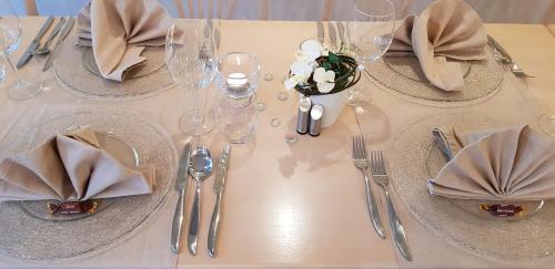 a table with a white table cloth with silverware and napkins at Landhaus Zum Heidewanderer mit THERMEplus in Bad Bevensen
