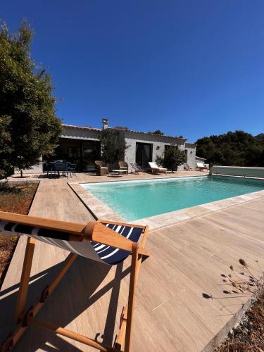 - une piscine avec une chaise à côté d'une maison dans l'établissement Villa Ena, à Figari