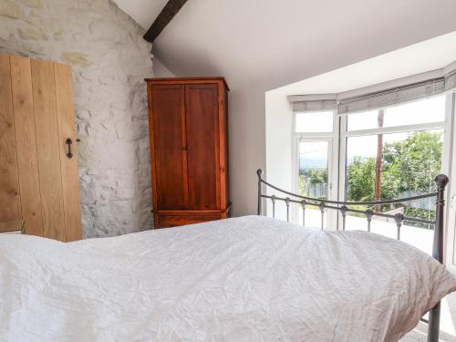 a bedroom with a bed and a window at Aster Cottage in Rhyl