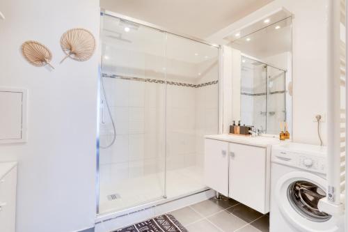 La salle de bains blanche est pourvue d'un lave-linge et d'une douche. dans l'établissement L'Ethnic Print - Paris Stade de France, à Aubervilliers