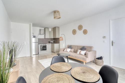 - un salon avec deux tables et un canapé dans l'établissement L'Ethnic Print - Paris Stade de France, à Aubervilliers