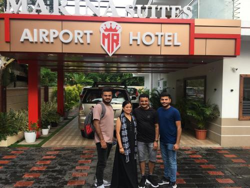 a group of four people standing in front of an airport hotel at MARINA SUITES AIRPORT HOTEL in Cochin