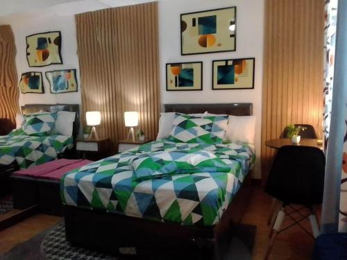 een slaapkamer met een bed en een stoel en foto's aan de muur bij Affordable staycation @Mesaverte Residences cdo in Cagayan de Oro