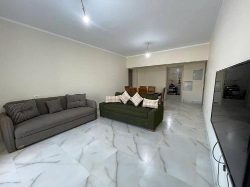 a living room with two couches and a flat screen tv at Alamein downtown north cost in El Alamein
