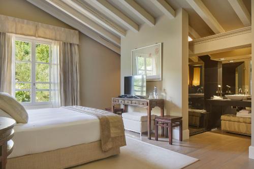 a bedroom with a bed and a bathroom with a sink at Hotel Iturregi in Getaria