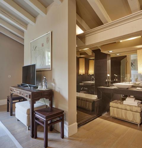 a bathroom with a sink and a desk with a television at Hotel Iturregi in Getaria