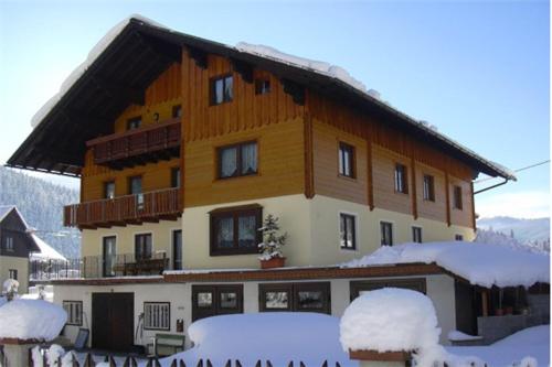 ein großes Gebäude mit Schnee davor in der Unterkunft Gästehaus Sams in Gosau