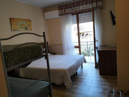a bedroom with a bed and a door to a balcony at Viole Country Hotel in Assisi