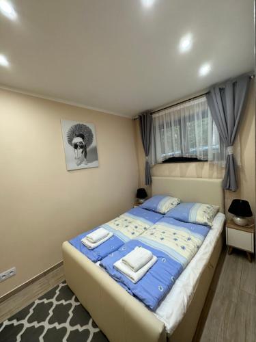 a bedroom with a bed with a blue comforter at Willa Alkor in Drzeńsko