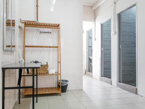 a bathroom with a black table and white tiles at Aayu Chulia in George Town