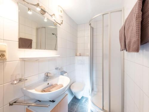 a white bathroom with a sink and a shower at Haus Anna in Längenfeld