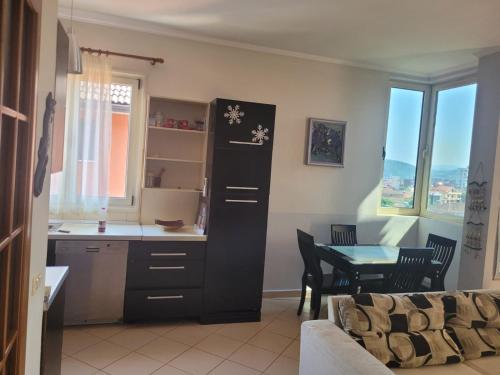 cocina y comedor con mesa y armario en Nice and friendly apartment, en Elbasan