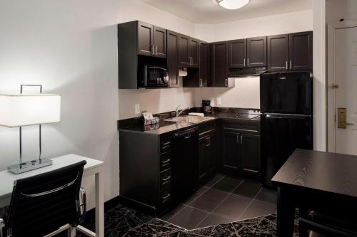 a kitchen with black cabinets and a black refrigerator at Residence Inn by Marriott Philadelphia Center City in Philadelphia