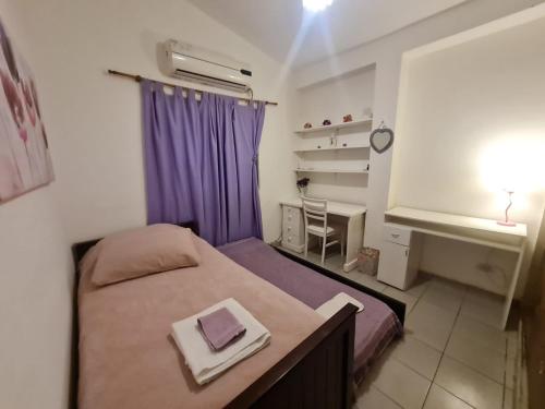 Habitación pequeña con cama y cortina púrpura en Casa cómoda y linda a 20min del centro. en Salta