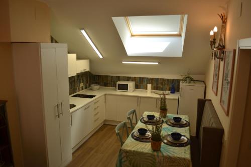 a kitchen with a table and a kitchen with a window at La Centralita de la Abuela in Segovia