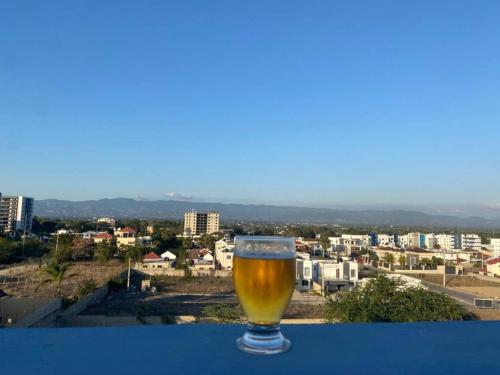 een glas bier bovenop een tafel bij Residencial Mena, penthouse in Santiago de los Caballeros