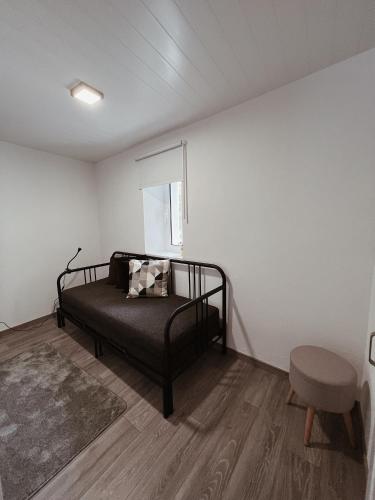 a bedroom with a black bed and a chair at Cantinhos Da Serra e Sopé, Soure in Soure
