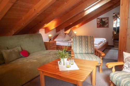 sala de estar con sofá y cama en Gänseblümchen -805-, en Mittenwald