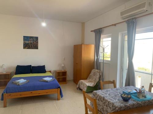1 dormitorio con cama, mesa y ventana en Perivoli Guest Rooms en Kókkinos Pírgos