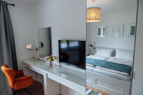 a bedroom with a bed and a desk with a television at Casa Melisa I 61m² I WLAN in Witten